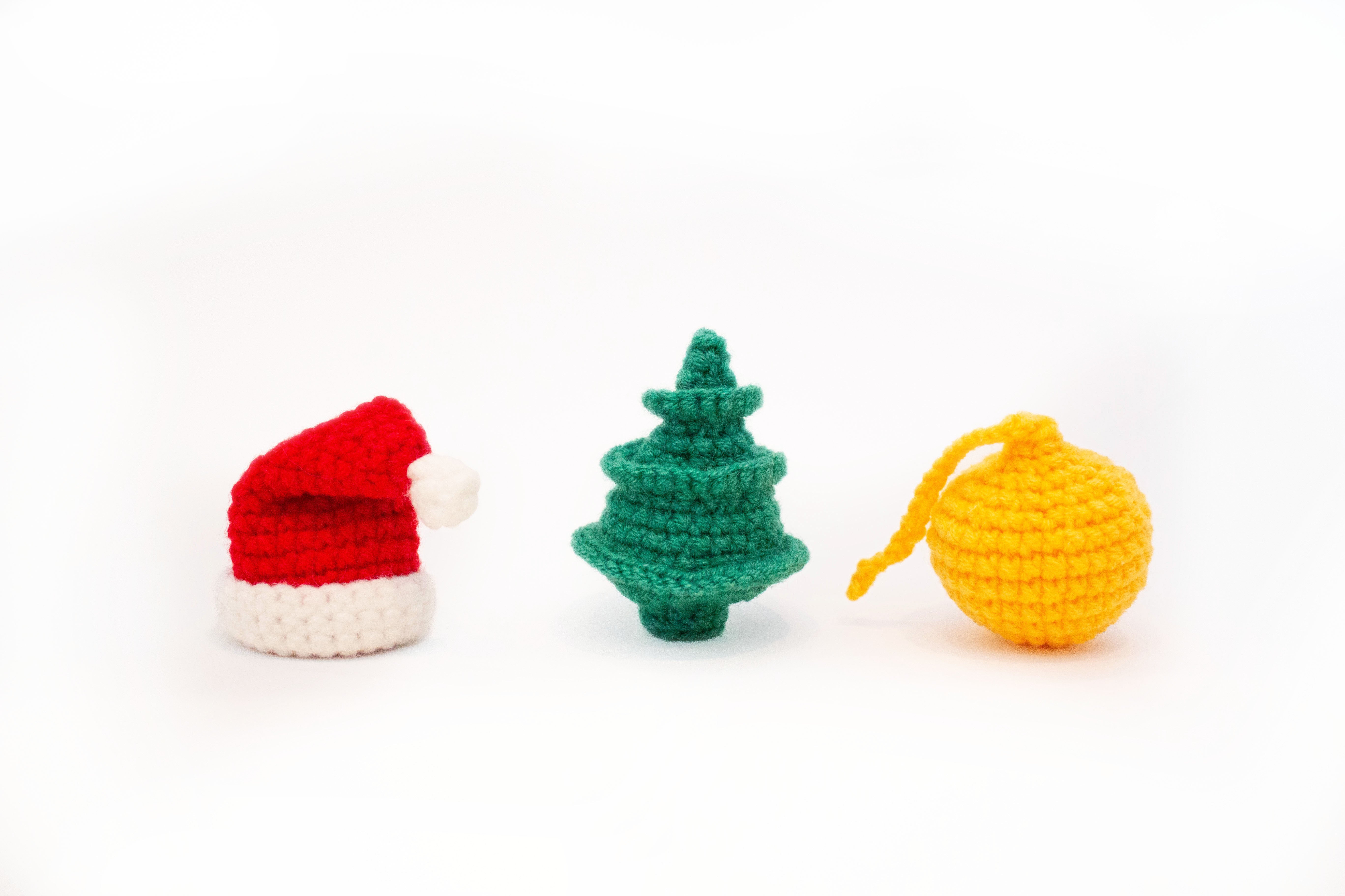 crocheted christmas cat toys on white background